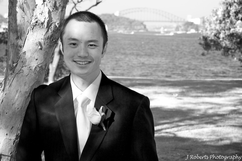 B&W of groom with sydney harbour behind - wedding photography sydney